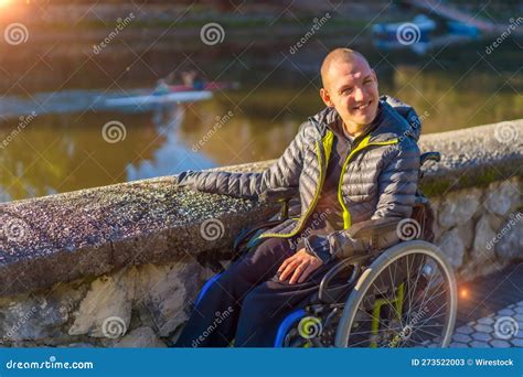 Persona in sedia a rotelle che usa un attrezzo da giardinaggio a manico lungo