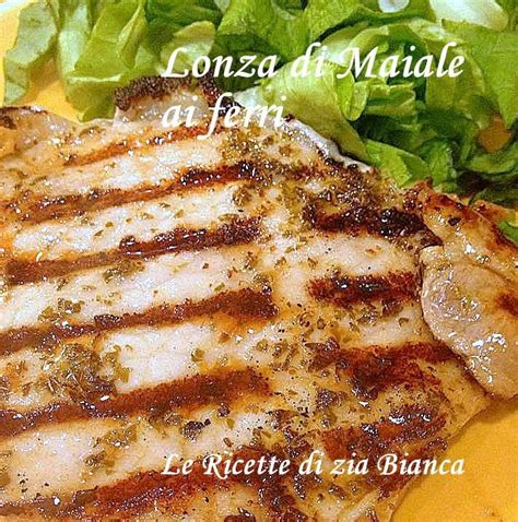 Fettine di lonza di maiale sulla griglia con segni di cottura