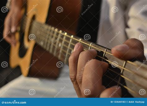 Chitarrista che muta le corde con la mano sinistra per esercitare lo strumming con la destra