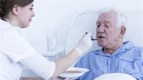 Un anziano sorridente mentre interagisce con un operatore sanitario