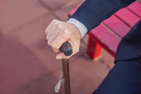 Anziano che tiene in mano un bastone da passeggio