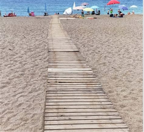 Passeggeri che utilizzano una passerella per accedere a una spiaggia