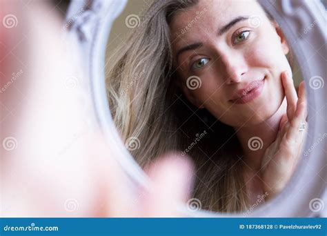 Persona che guarda tristemente il proprio riflesso