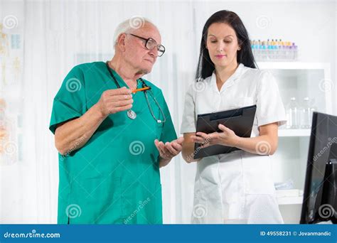 Medico anziano assistito da un infermiere