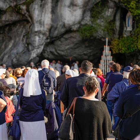 Volontari Unitalsi che assistono un pellegrino a Lourdes