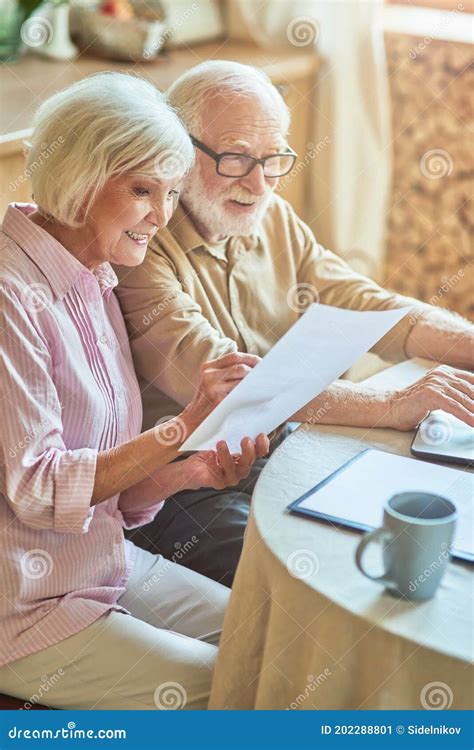Coppia anziana che discute documenti legali