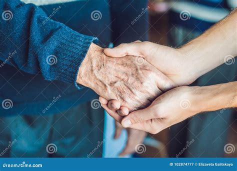 Mani di una persona anziana e di una persona giovane che si stringono