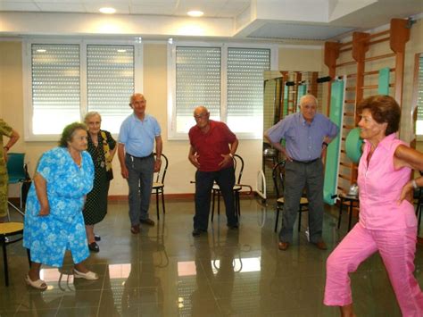 Anziani che partecipano a un'attività di gruppo in una sala luminosa