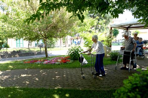 Anziani che passeggiano in un giardino curato