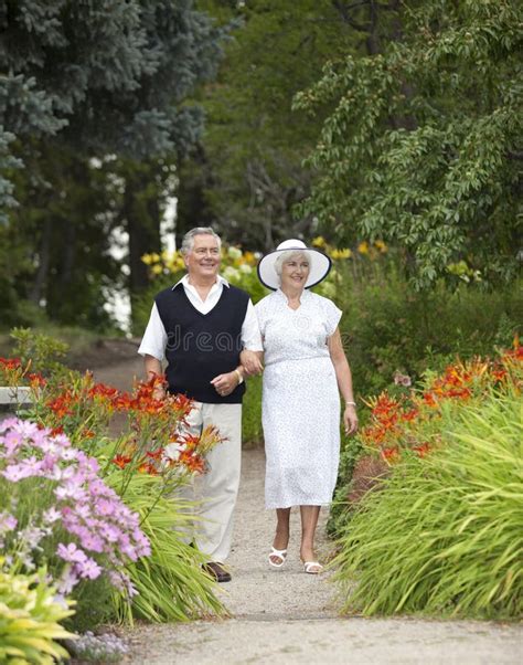 Coppia anziana che passeggia mano nella mano in un parco