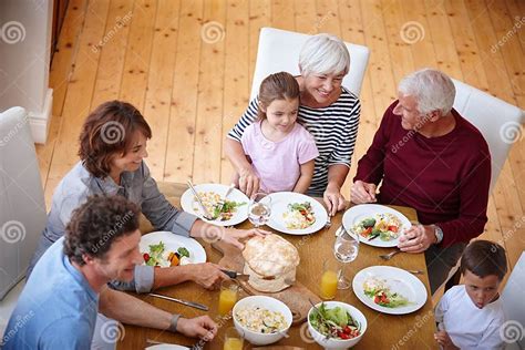 Famiglia multigenerazionale che condivide un pasto