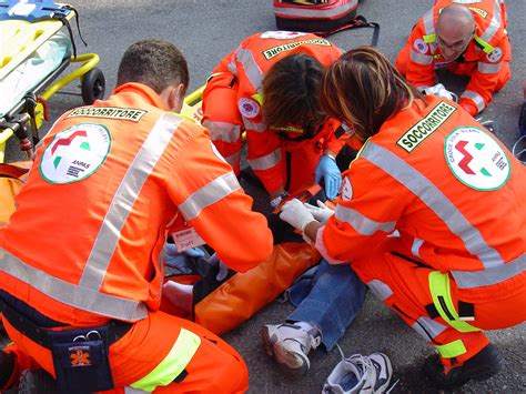 Volontari del soccorso che caricano un paziente su un'ambulanza